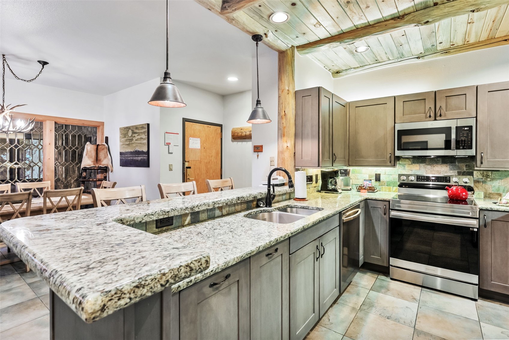 1201 West Keystone Road, Unit 2724 Keystone, CO 80435 - Photo 7 of 28 Kitchen with kitchen peninsula, appliances with stainless steel finishes, and decorative light fixtures