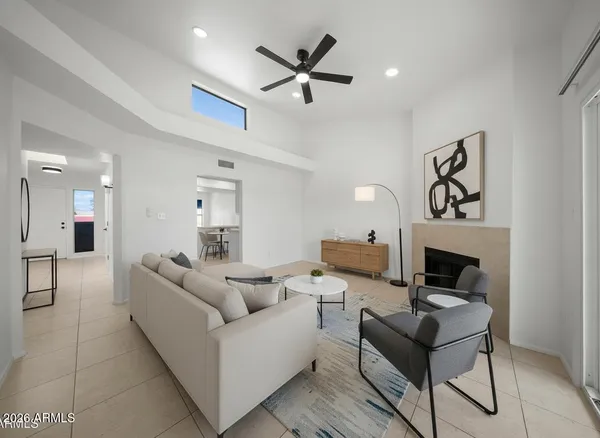 a living room with furniture a fireplace and a ceiling fan