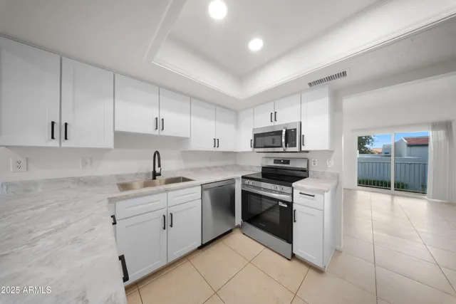 a kitchen with stainless steel appliances granite countertop a sink and stove top oven