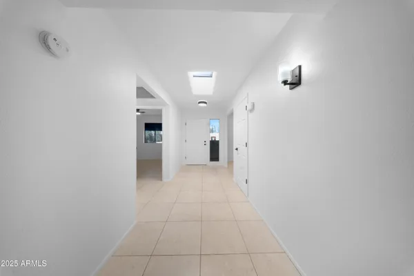 a view of a hallway with wooden cabinet and a bathroom