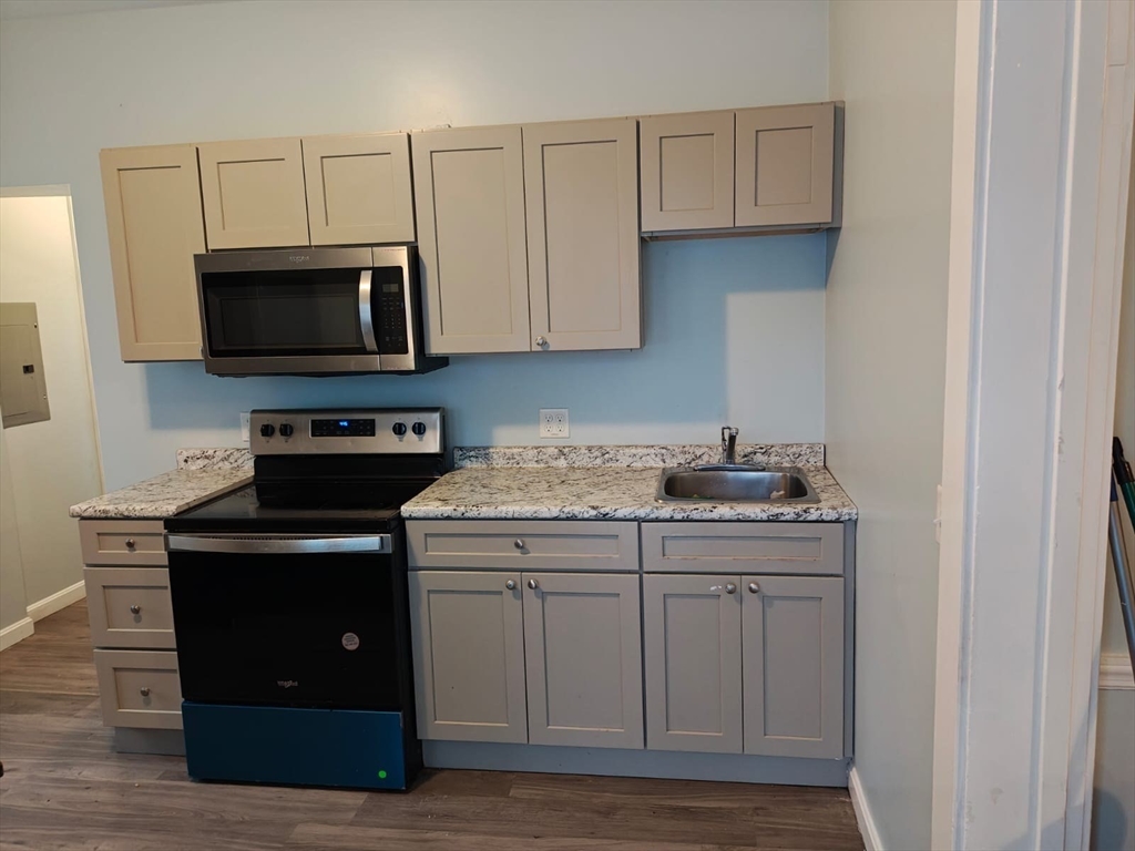 115 Maple Street, Unit 3 Gardner, MA 01440 - Photo 1 of 12 a kitchen with stainless steel appliances granite countertop a stove and a microwave