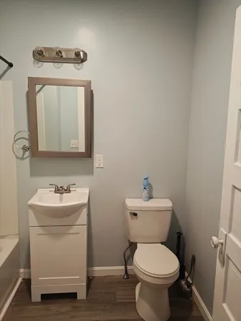 a bathroom with a toilet sink and mirror