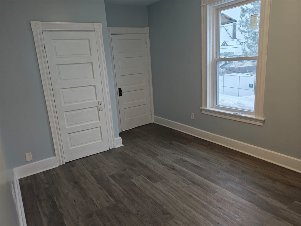 115 Maple Street, Unit 3 Gardner, MA 01440 - Photo 10 of 12 an empty room with wooden floor closet and windows