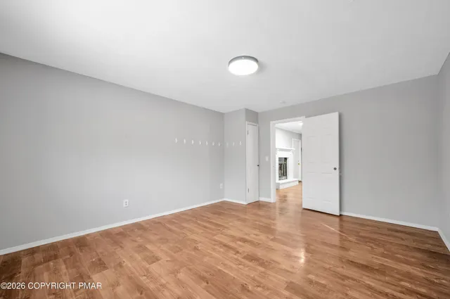 a view of empty room with wooden floor