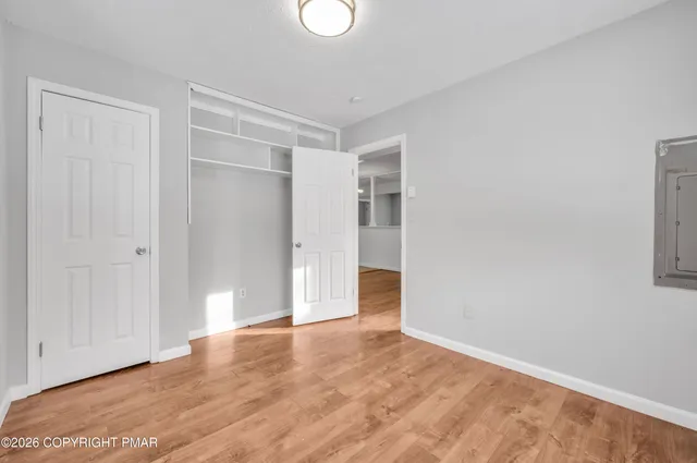 a view of an empty room with wooden floor