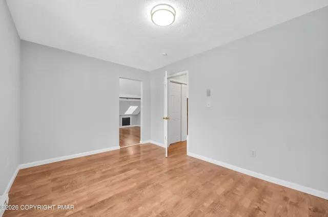 a view of a big room with wooden floor and windows