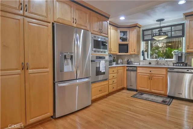 a kitchen with granite countertop a stove and white cabinets with wooden floor