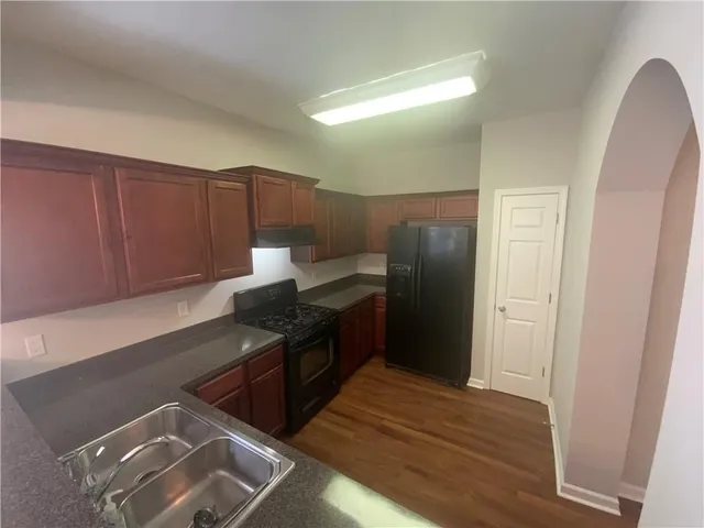 a kitchen with stainless steel appliances granite countertop a refrigerator and a stove