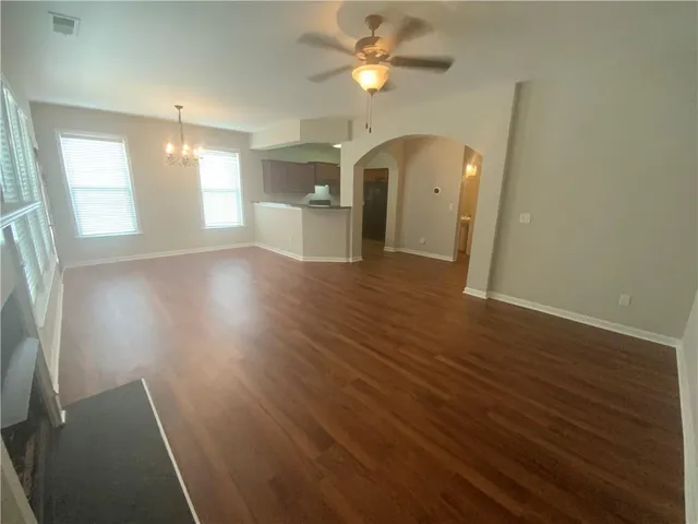 a view of an empty room with a kitchen and a fireplace