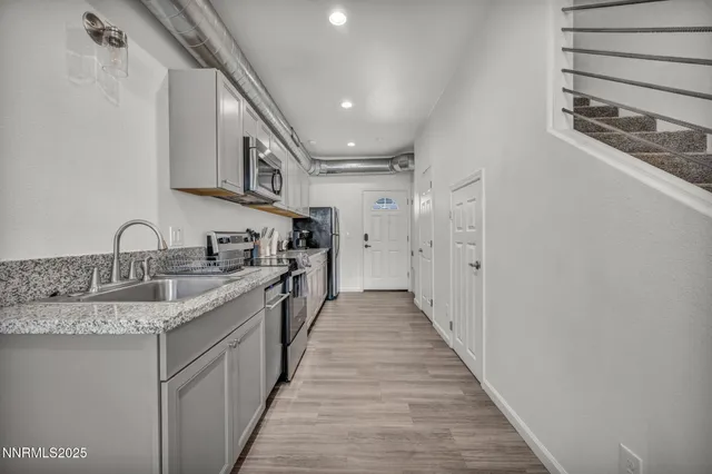 a kitchen with stainless steel appliances granite countertop a sink a stove top oven and granite counter tops