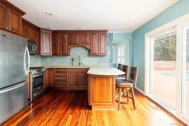 a kitchen with granite countertop wooden floors and stainless steel appliances