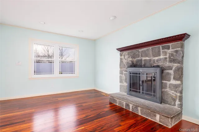 a living room with wooden floor and a fireplace