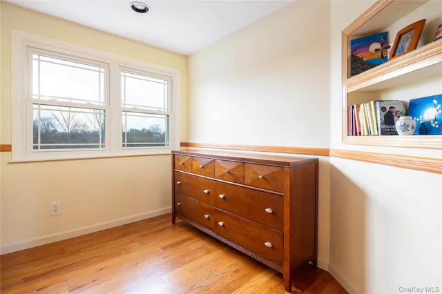 an empty room with a window and wooden floor