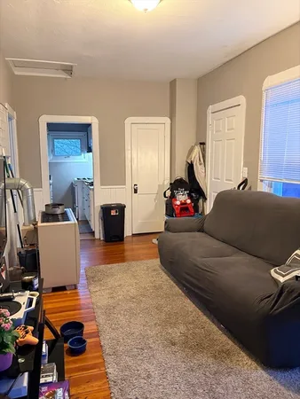 a living room with furniture a flat screen tv and a window
