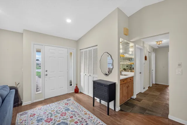 a kitchen with stainless steel appliances kitchen island granite countertop a table chairs sink and cabinets