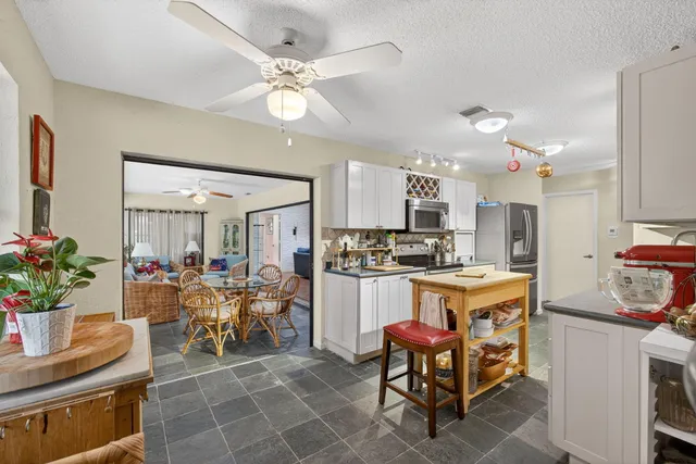 a kitchen with stainless steel appliances kitchen island granite countertop a stove a sink and a refrigerator