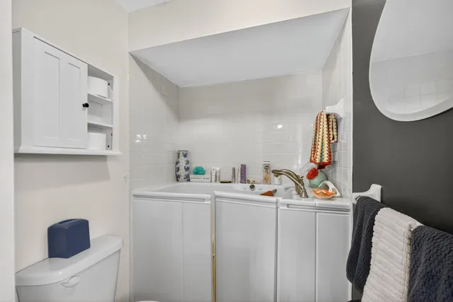 a bathroom with a sink a toilet and a mirror