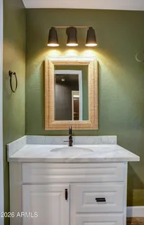 a bathroom with a double vanity sink a large mirror and shower