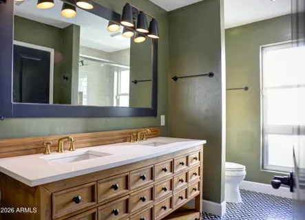 a kitchen with granite countertop a table chairs wooden floors and a view of living room