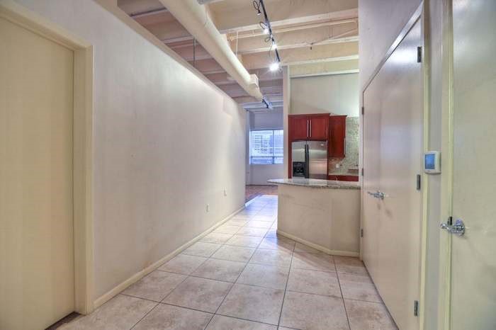 705 Main Street, Unit 315 Houston, TX 77002 - Photo 4 of 16 a kitchen with granite countertop a refrigerator and a sink