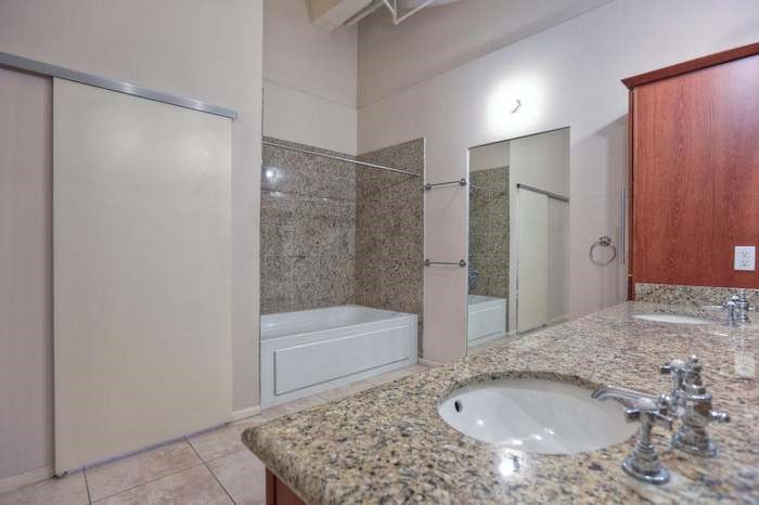 705 Main Street, Unit 315 Houston, TX 77002 - Photo 10 of 16 a bathroom with a granite countertop sink and a mirror
