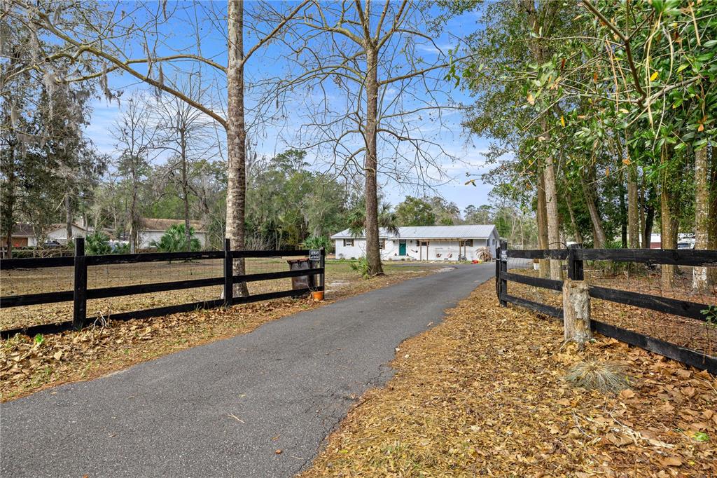 5100 Southeast 44th Avenue Road Ocala, FL 34480 - Photo 2 of 41 a street view with wooden fence and trees