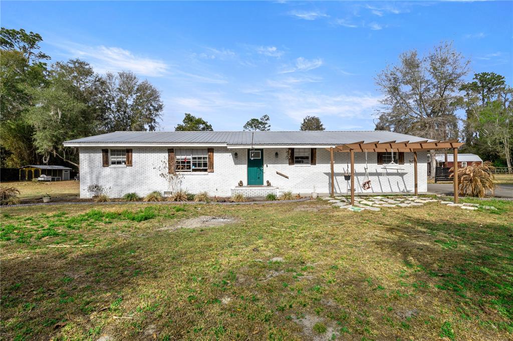 5100 Southeast 44th Avenue Road Ocala, FL 34480 - Photo 3 of 41 a view of a house with a big yard and potted plants