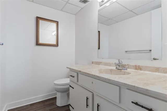 a bathroom with a granite countertop toilet sink and mirror