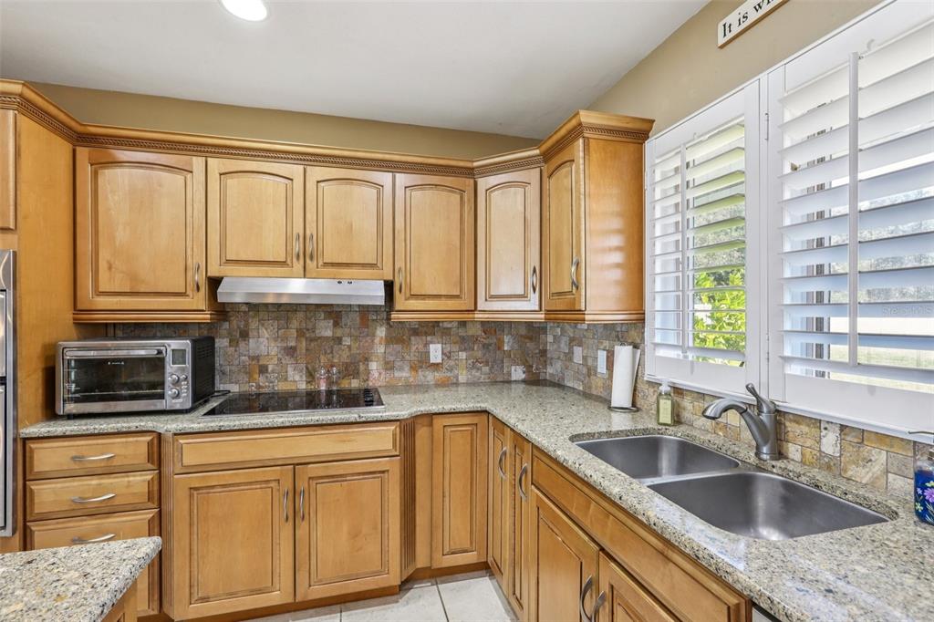3050 Crump Road Winter Haven, FL 33881 - Photo 27 of 98 a kitchen with granite countertop a sink and a window