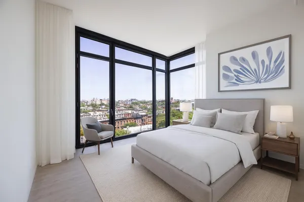 a bedroom with a bed and a large window