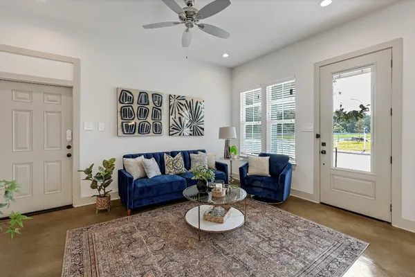 a kitchen with kitchen island a dining table chairs a sink and a refrigerator