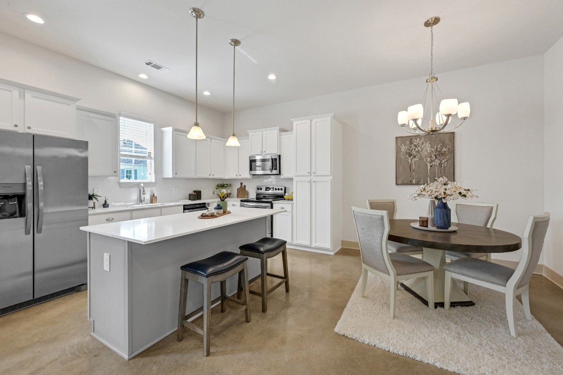 33455 Buckshot Lane, Unit 52 Spring, TX 77382 - Photo 6 of 25 a kitchen with kitchen island a dining table chairs a sink and a refrigerator