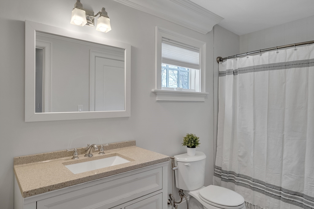 80 Buckman Drive Lexington, MA 02421 - Photo 11 of 29 a bathroom with a granite countertop sink toilet a mirror and a shower