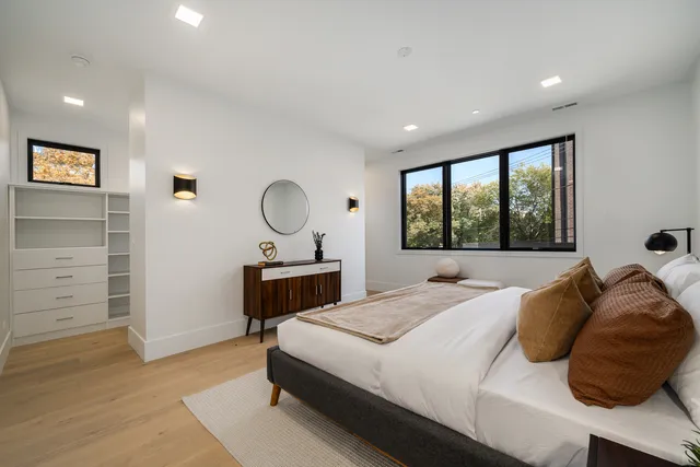 a bedroom with a bed a dresser and a window