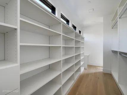 a view of walk in closet with empty racks