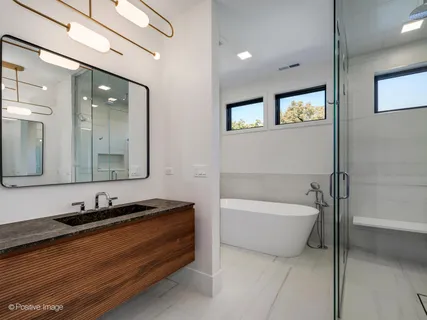 a bathroom with a bathtub double vanity sink and mirror