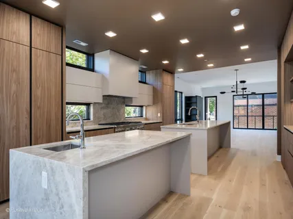 a large kitchen with granite countertop a large counter top stainless steel appliances and cabinets