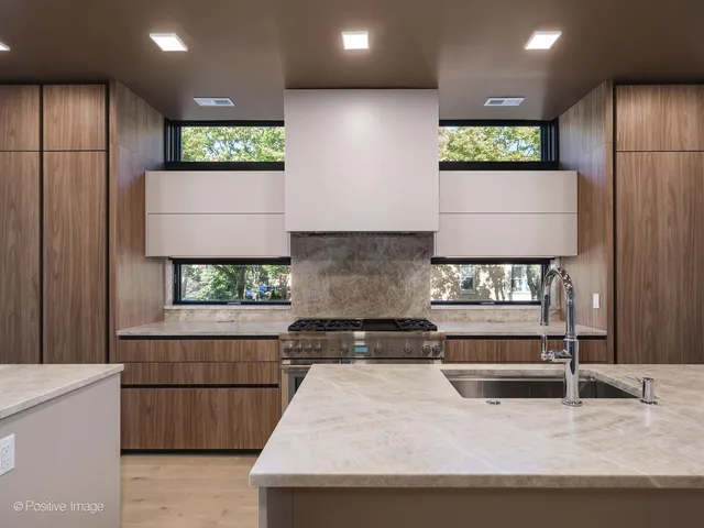 a kitchen with stainless steel appliances kitchen island granite countertop a refrigerator and a stove