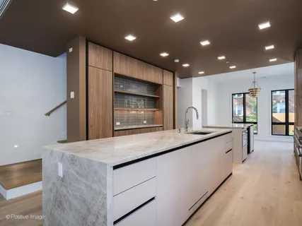 a large kitchen with kitchen island a sink stainless steel appliances and cabinets