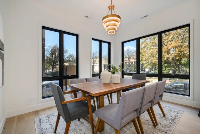 a view of a dining room with furniture large windows and wooden floor