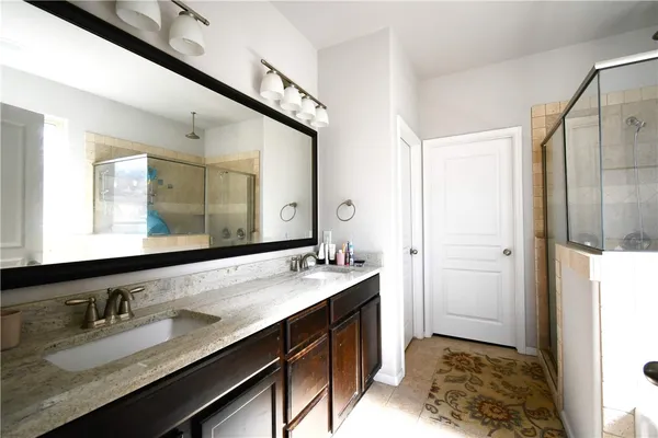 a bathroom with a granite countertop sink and a mirror