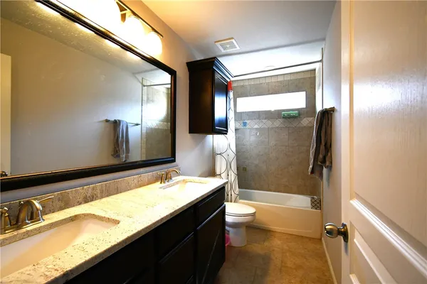 a bathroom with a granite countertop sink toilet and shower