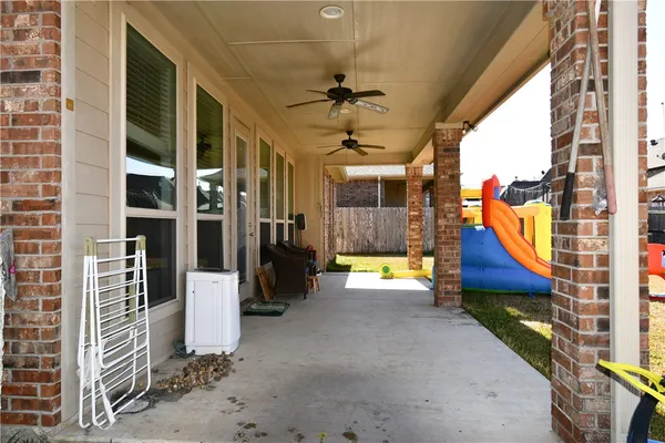 a view of a swimming pool with a couch and table in front of a house