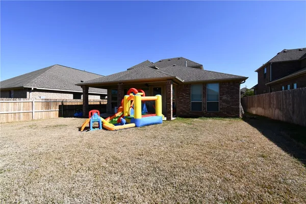 a view of a house with a patio and a yard