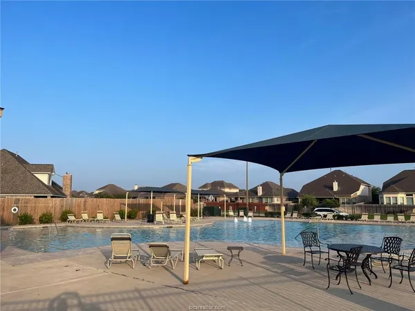 a view of a terrace with furniture and an umbrella
