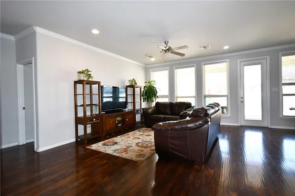 a living room with furniture a flat screen tv and a floor to ceiling window