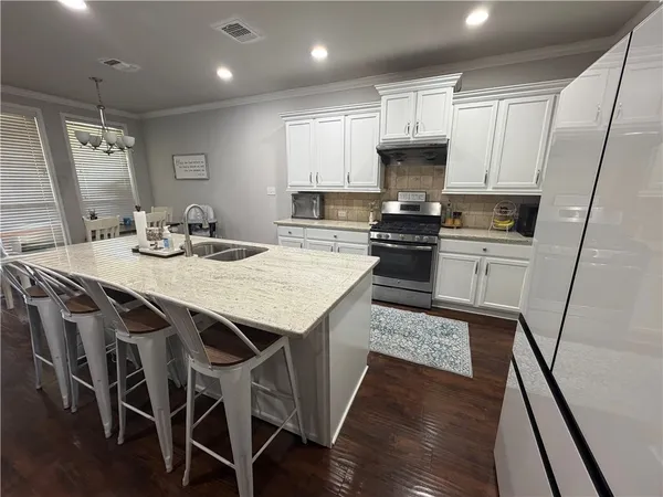 a kitchen with kitchen island granite countertop wooden floors and stainless steel appliances