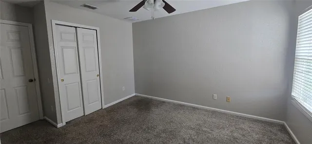 an empty room with a ceiling fan and wooden floor