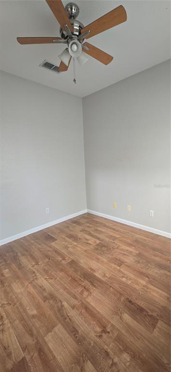 13426 Chariho Lane Windermere, FL 34786 - Photo 50 of 80 an empty room with a ceiling fan and wooden floor