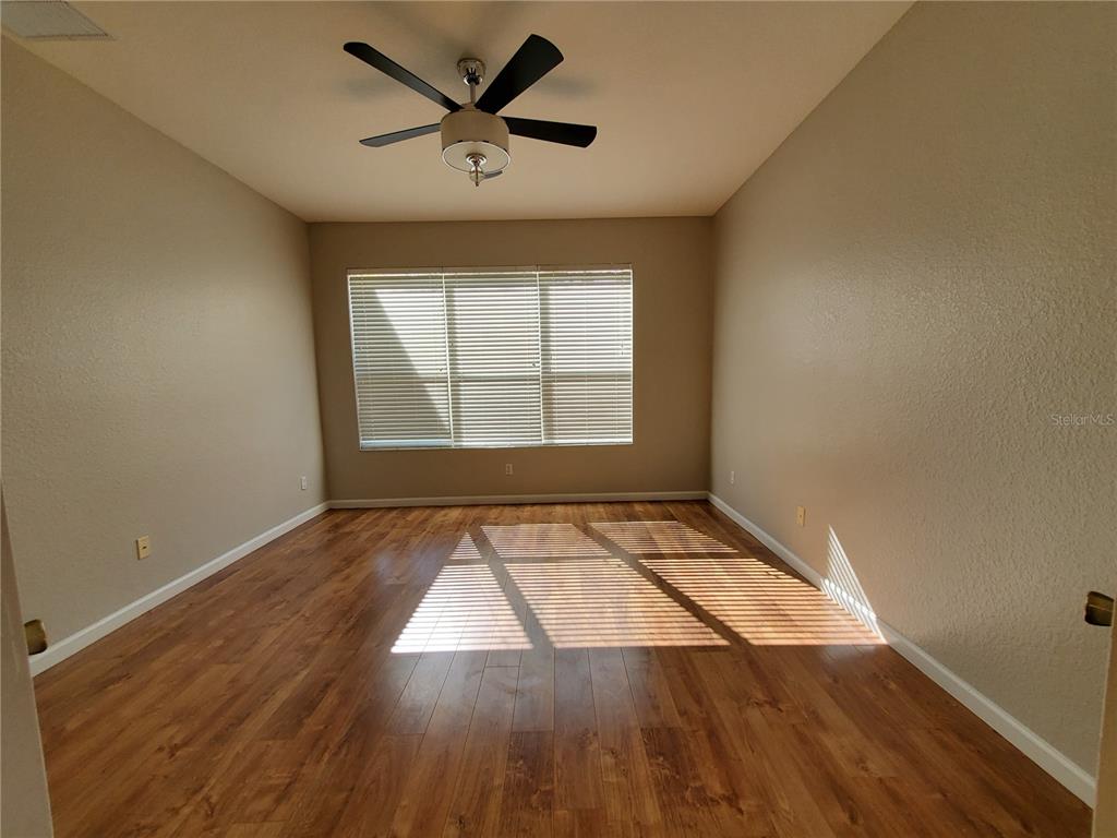 13426 Chariho Lane Windermere, FL 34786 - Photo 6 of 80 an empty room with wooden floor and windows